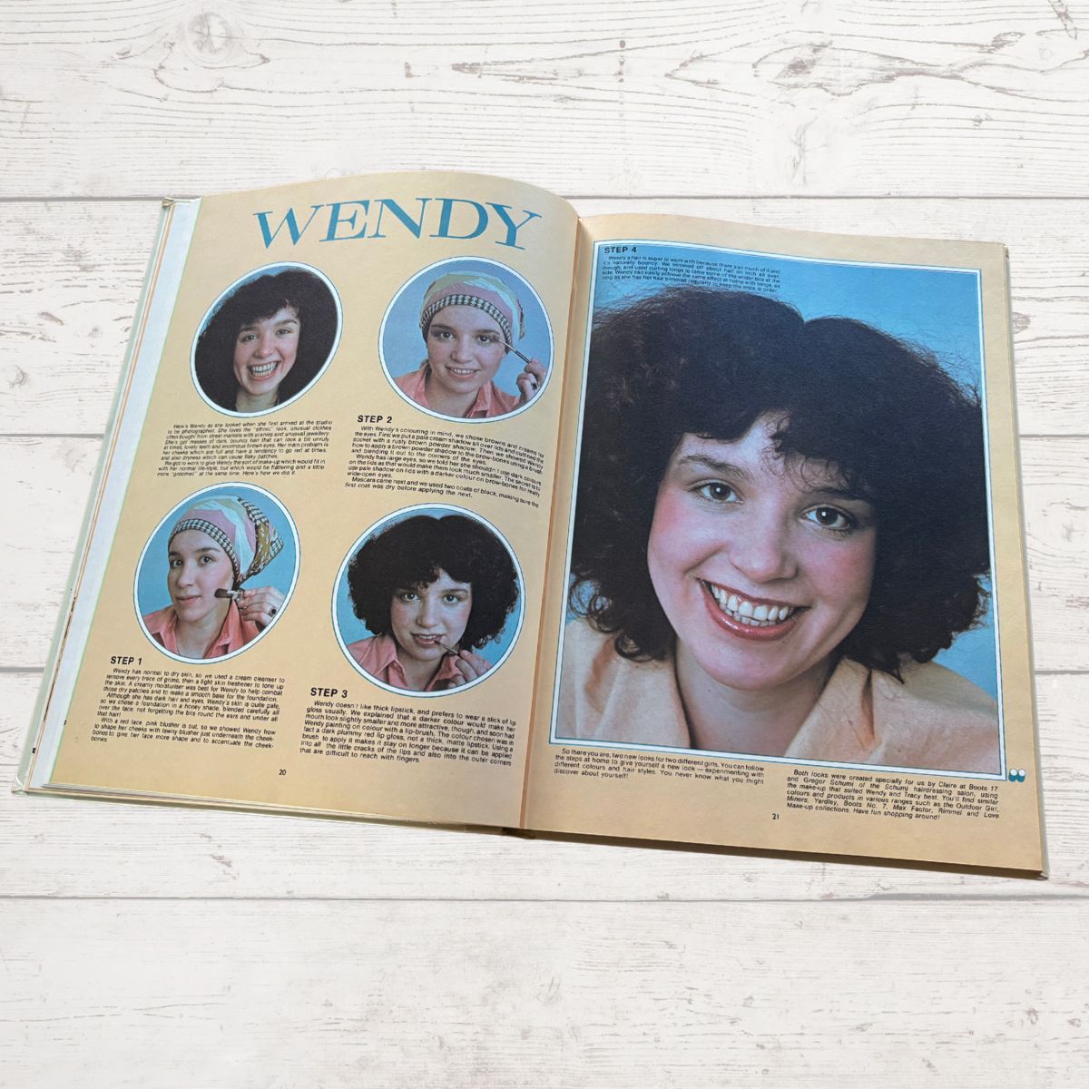 Open book showing a page with a woman's face and step-by-step instructions on a light wooden surface.