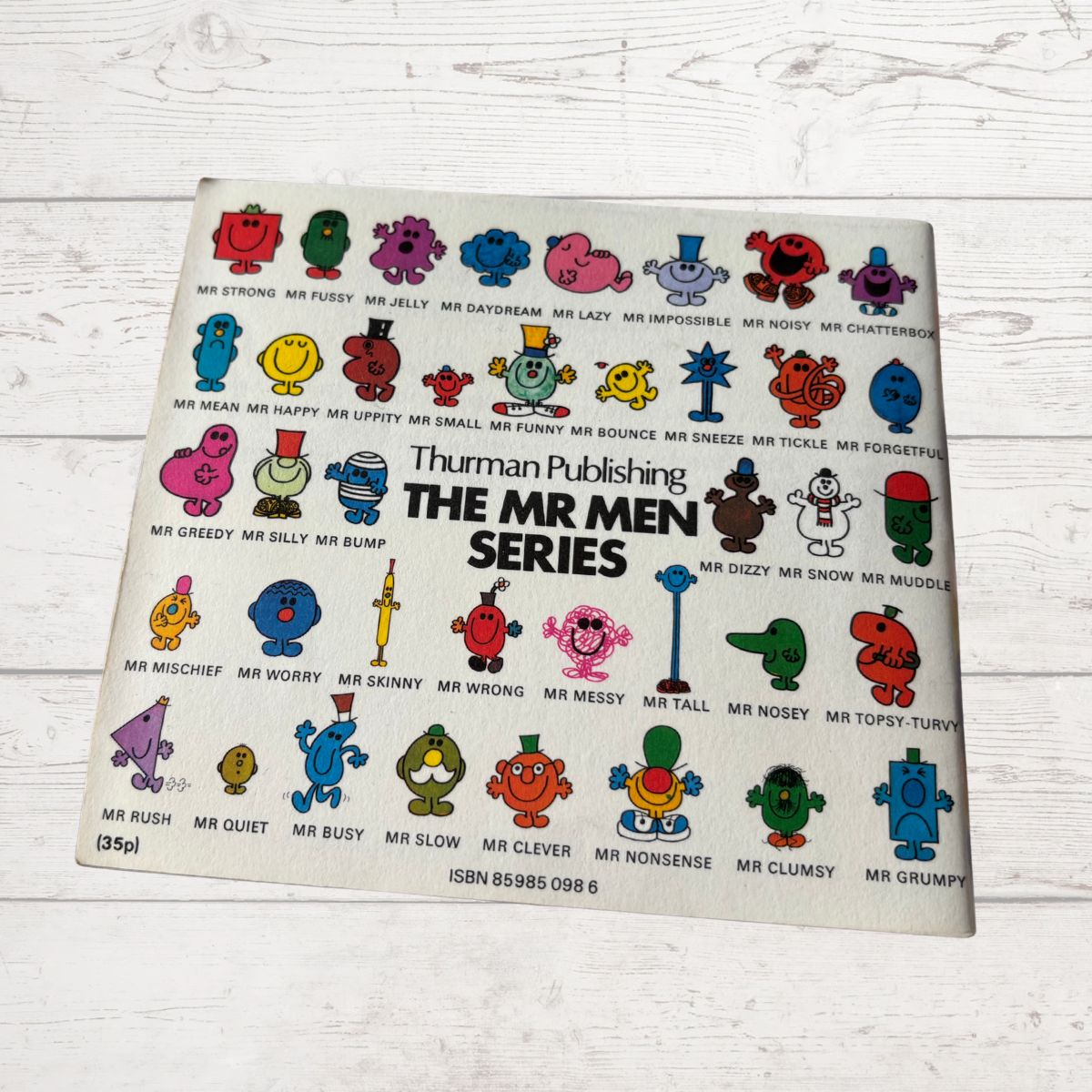 Vintage book cover of 'The Mr Men Series' by Thruman Publishing on a wooden surface.