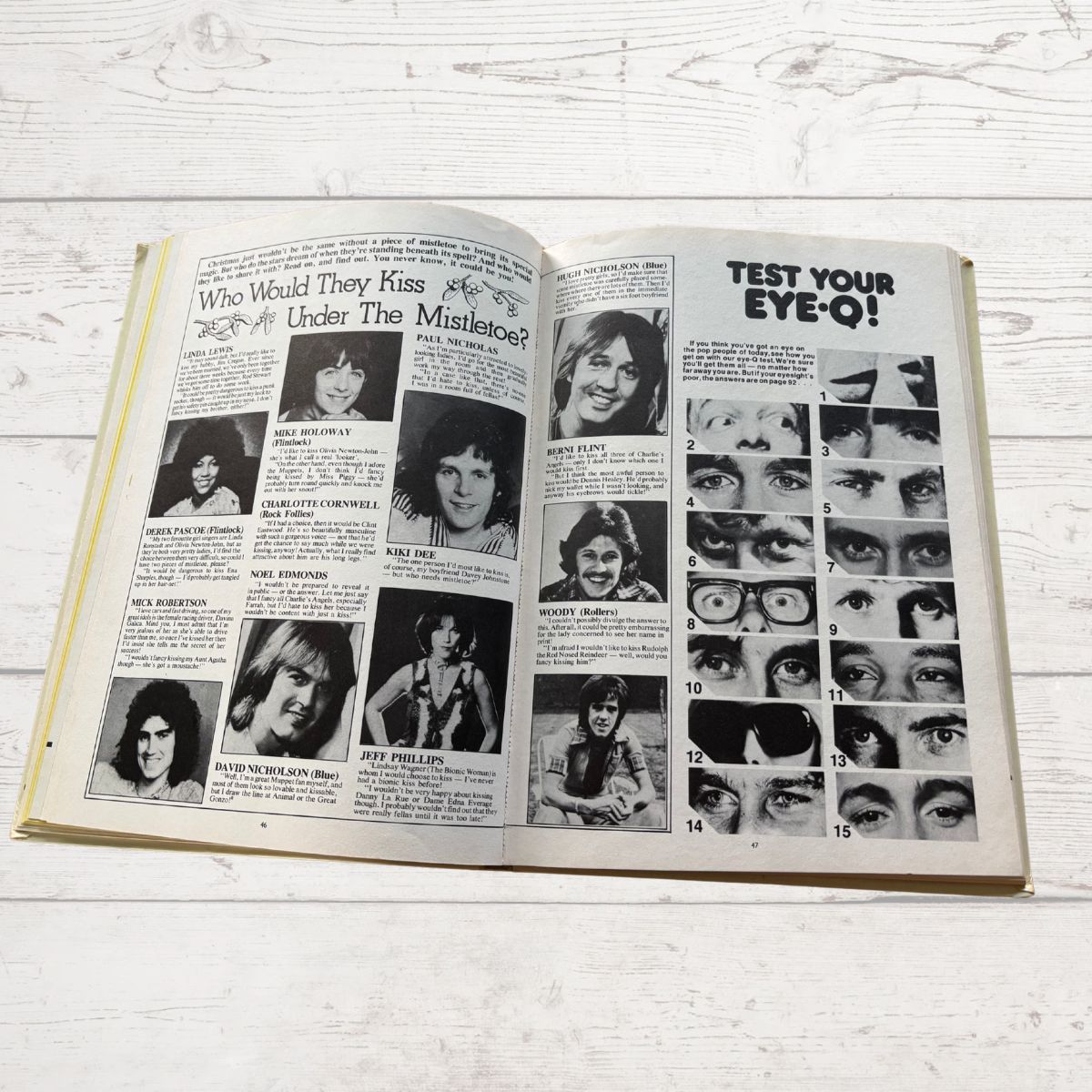 Open book with black and white photos and text on a light wooden surface