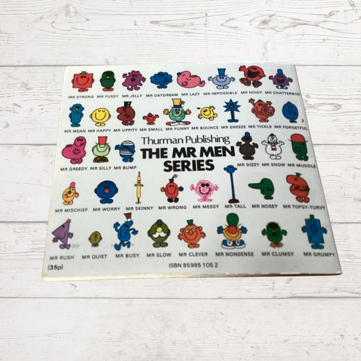 Book cover of 'The Mr Men Series' by Thruman Publishing on a wooden surface