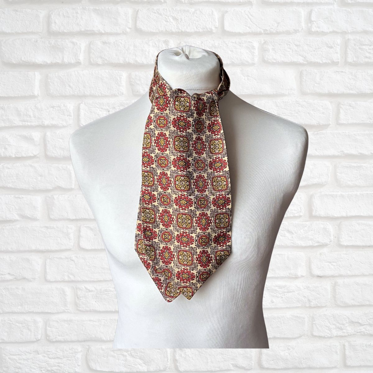 Patterned 60s cravat on a mannequin against a white brick wall background