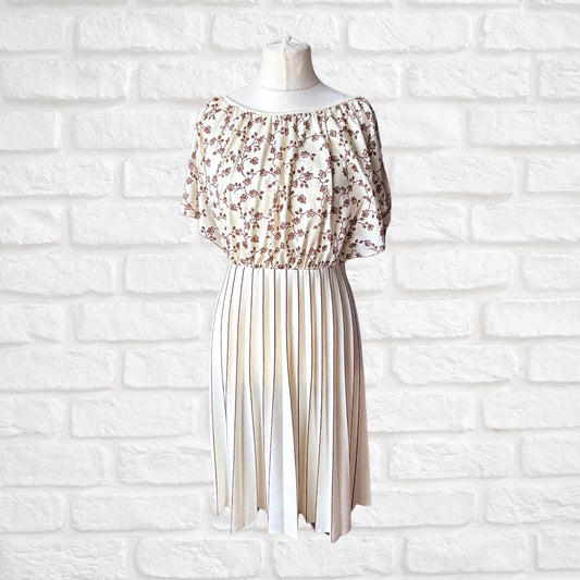A vintage 1970s cream and brown midi dress with a floral bodice and angel sleeves displayed on a mannequin against a white brick wall.