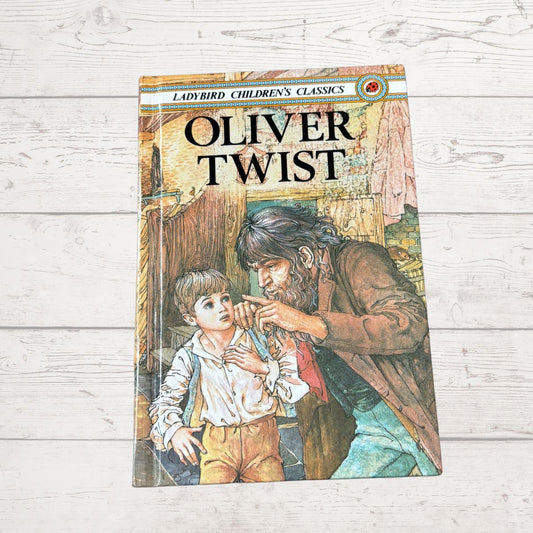 Book titled 'Oliver Twist' by Ladybird Children's Classics on a wooden surface