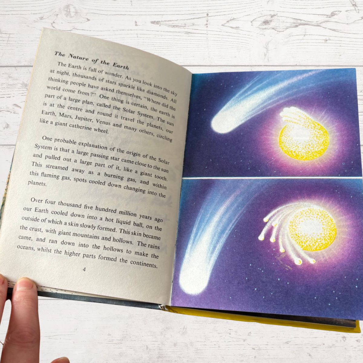 Open book with educational content on a celestial theme, featuring comets and stars.