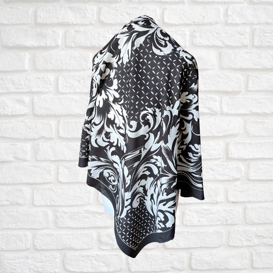 Black and white patterned scarf draped over a white brick wall