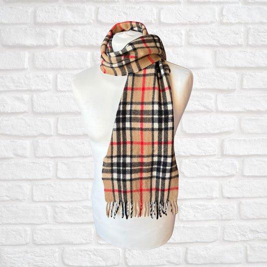 Plaid scarf on a mannequin against a white brick wall background