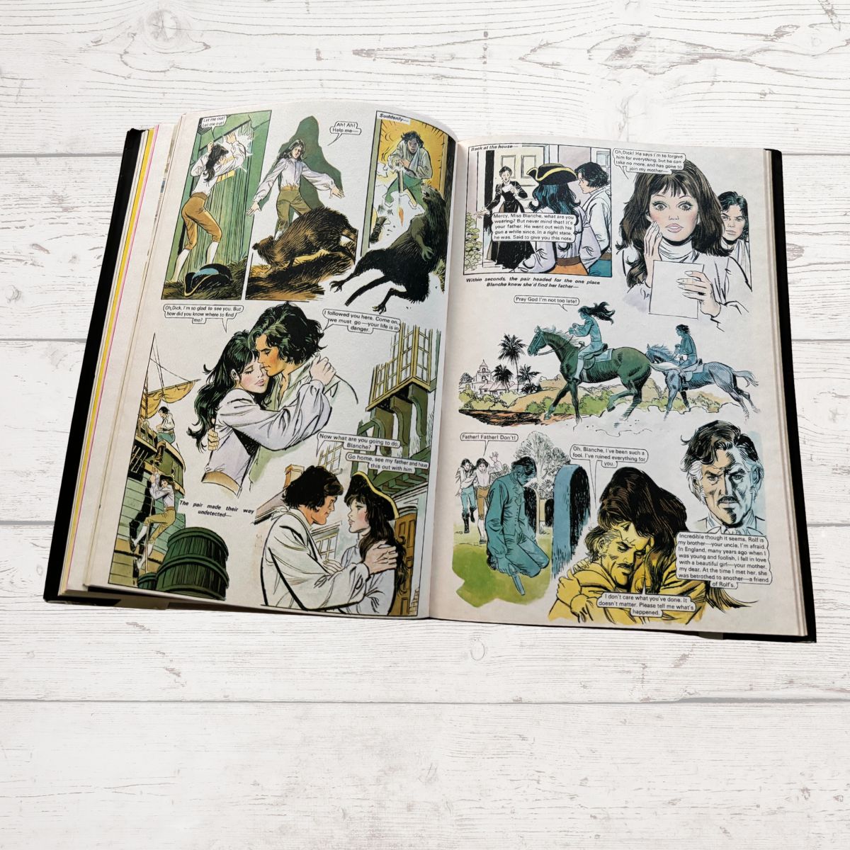 Open book with comic-style illustrations on a white wooden surface