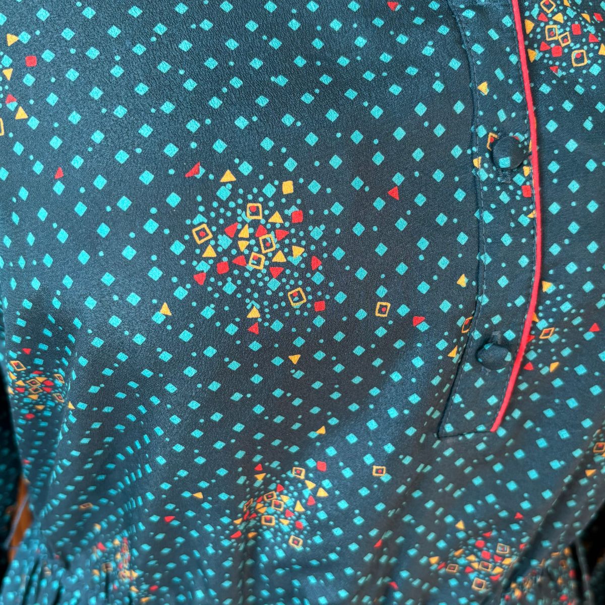 Close-up of a dress with a colourful geometric pattern on a dark blue background
