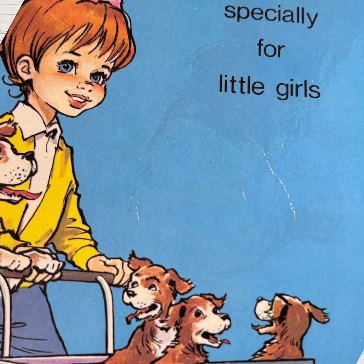 Vintage children's book cover illustration featuring a young girl with orange hair in a yellow jacket pushing three brown dogs on a blue background with the text 'specially for little girls'.