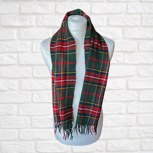 Plaid scarf on a mannequin against a white brick wall background