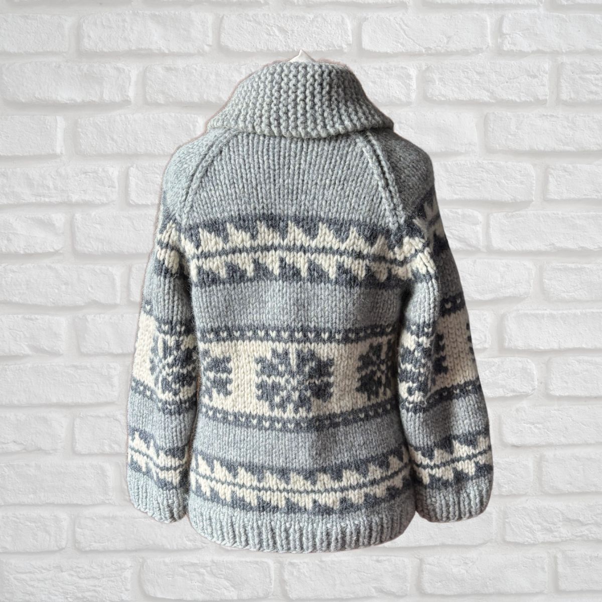 Knitted sweater with a pattern on a white brick wall background
