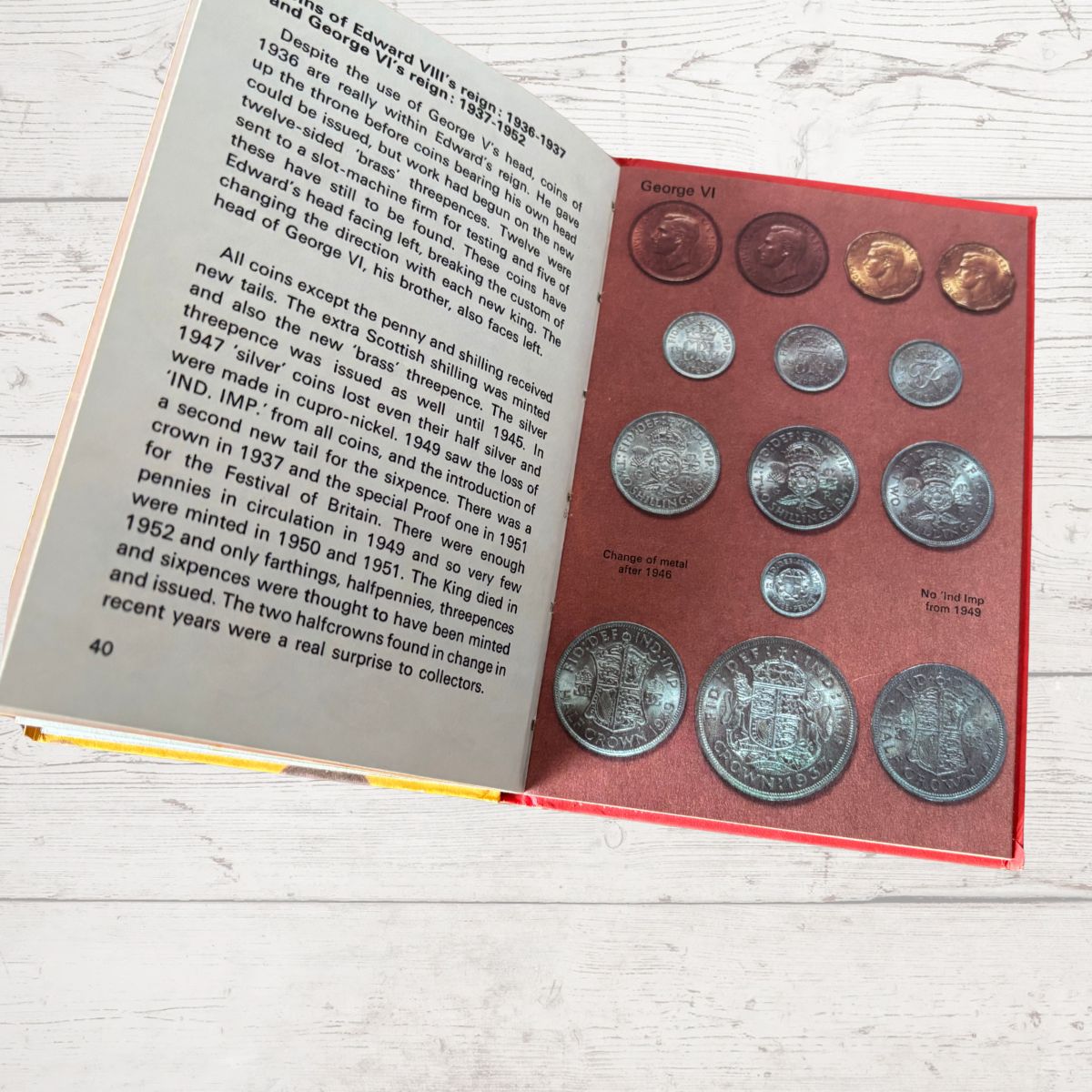 Collection of coins in a holder with an open book on a wooden surface