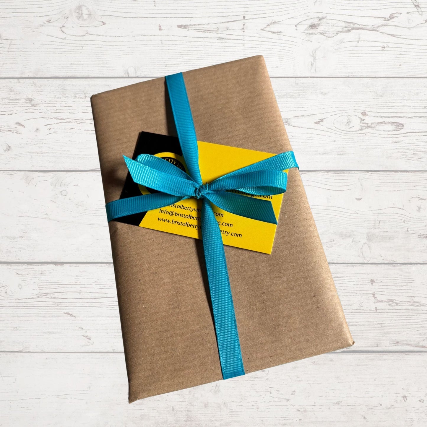 Wrapped book in brown Kraft paper and ribbon on a white background