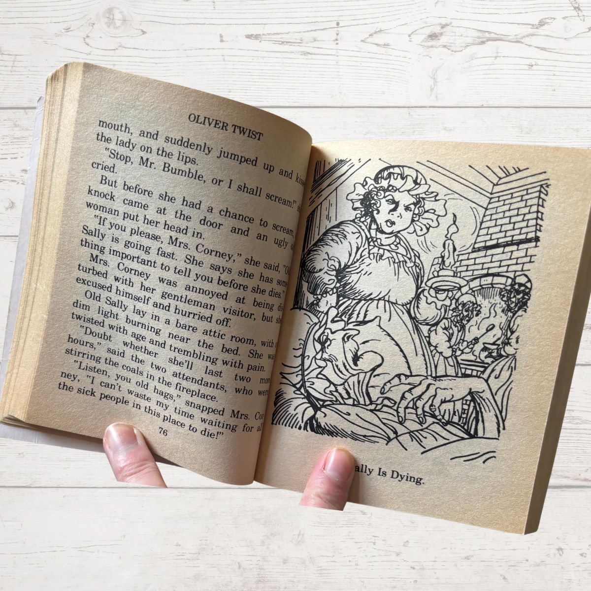 Open book with text and illustration on a wooden surface