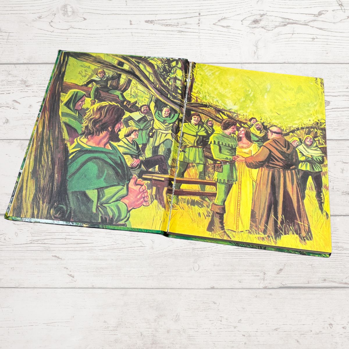 Open book with colorful illustrations on a wooden surface