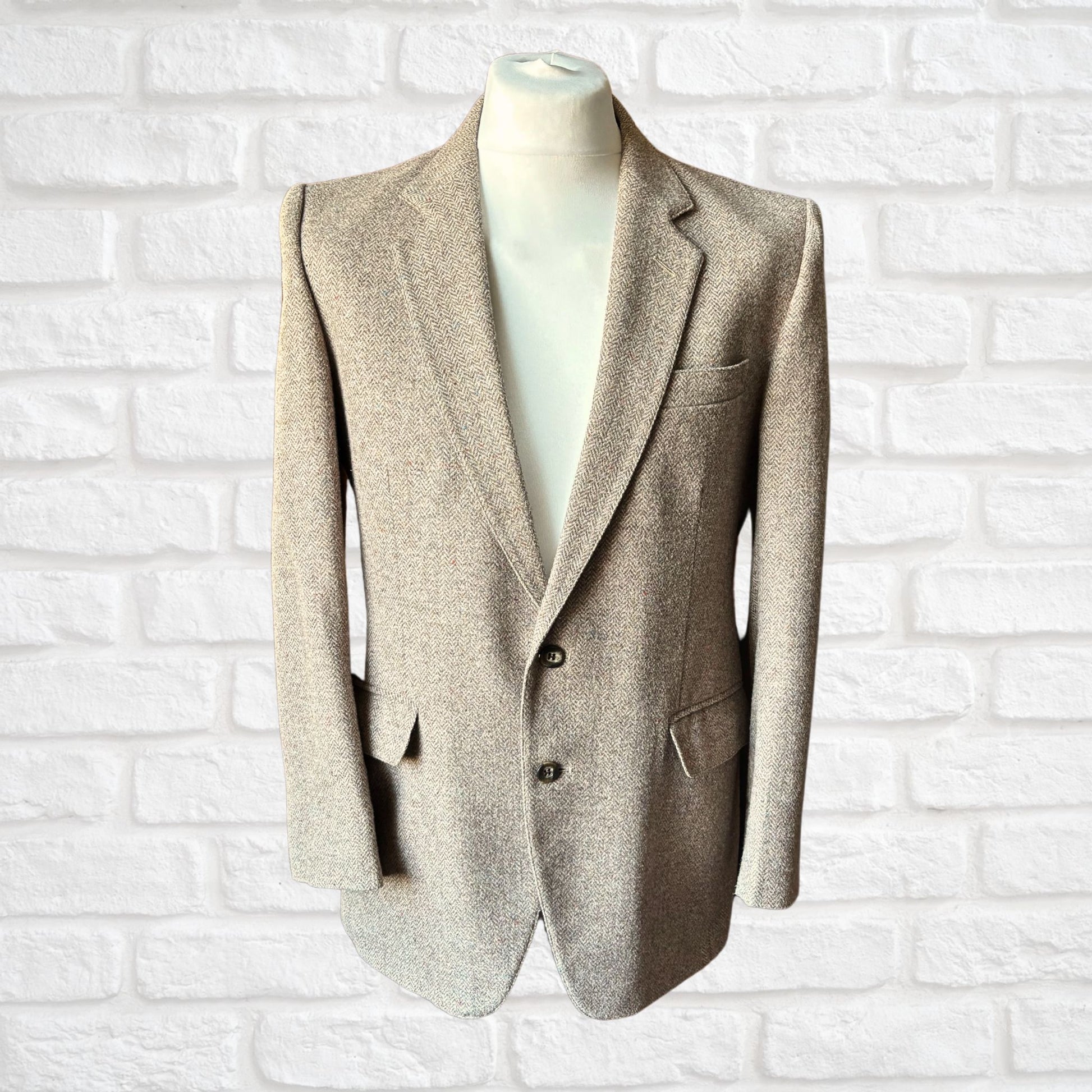 Beige blazer on a mannequin against a white brick wall background