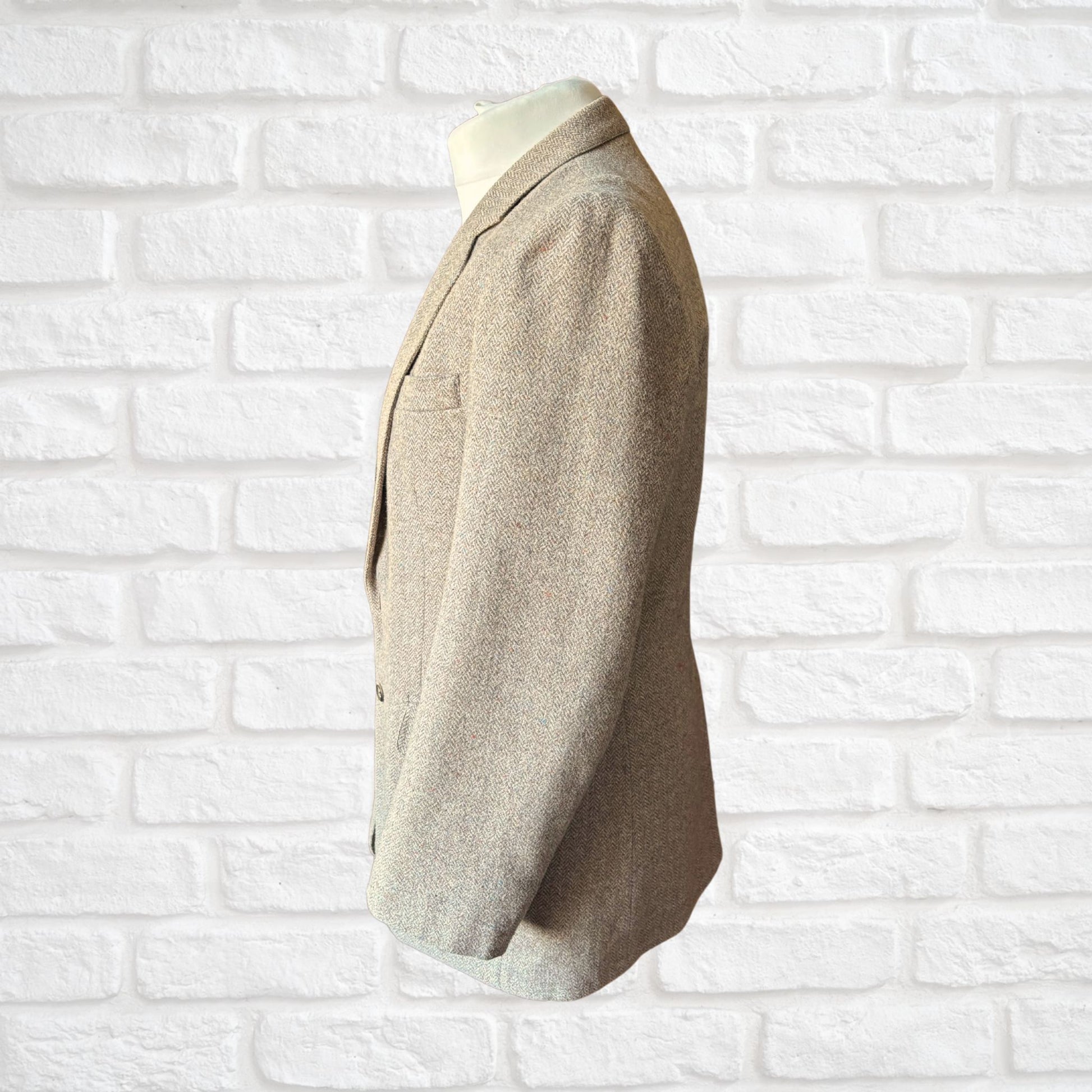 Beige blazer on a mannequin against a white brick wall background