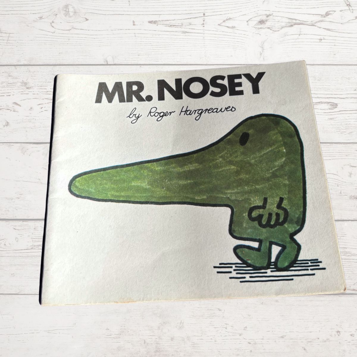 Book titled 'Mr. Nosey' by Roger Hargreaves on a wooden surface