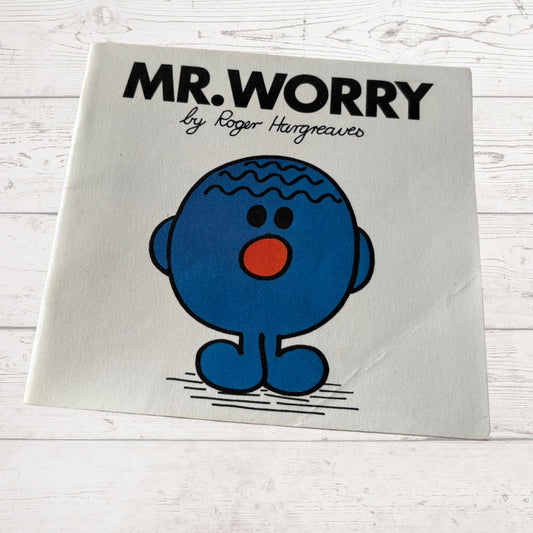 Book cover of 'Mr. Worry' by Roger Hargreaves on a light wooden surface.
