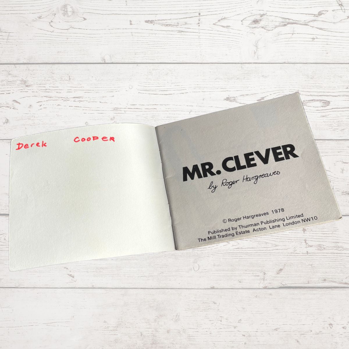 Open book with 'MR. CLEVER' by Roger Hargreaves on a light wooden surface