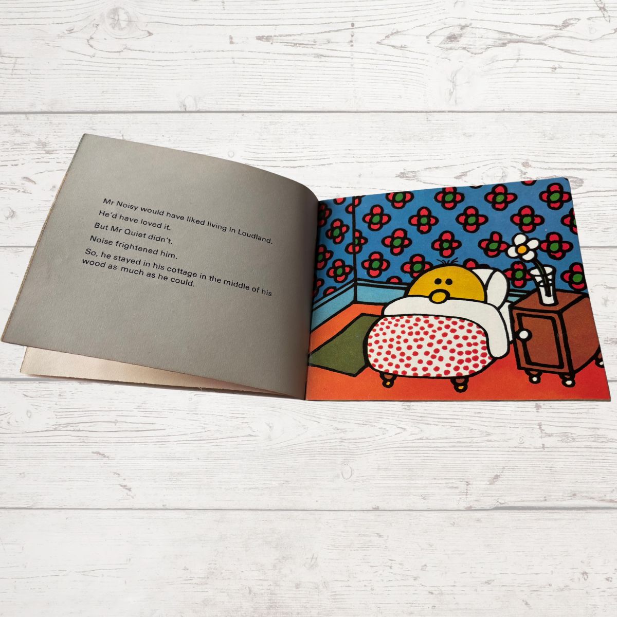 Open book with a colorful illustration of a character on a wooden surface