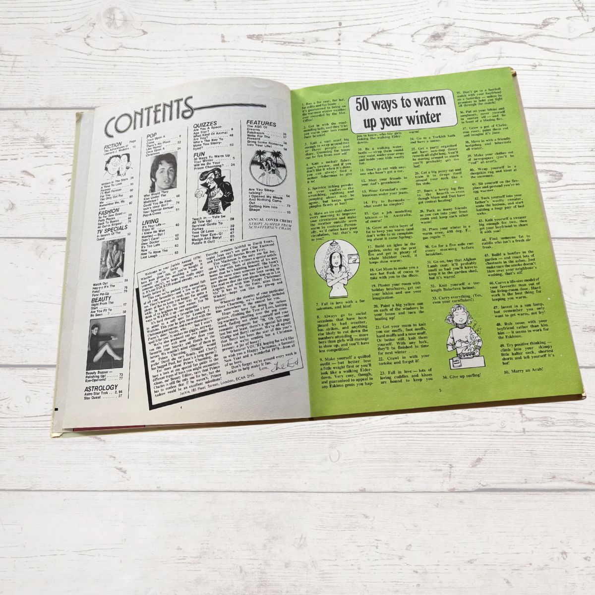 Open book with green and white pages on a wooden surface