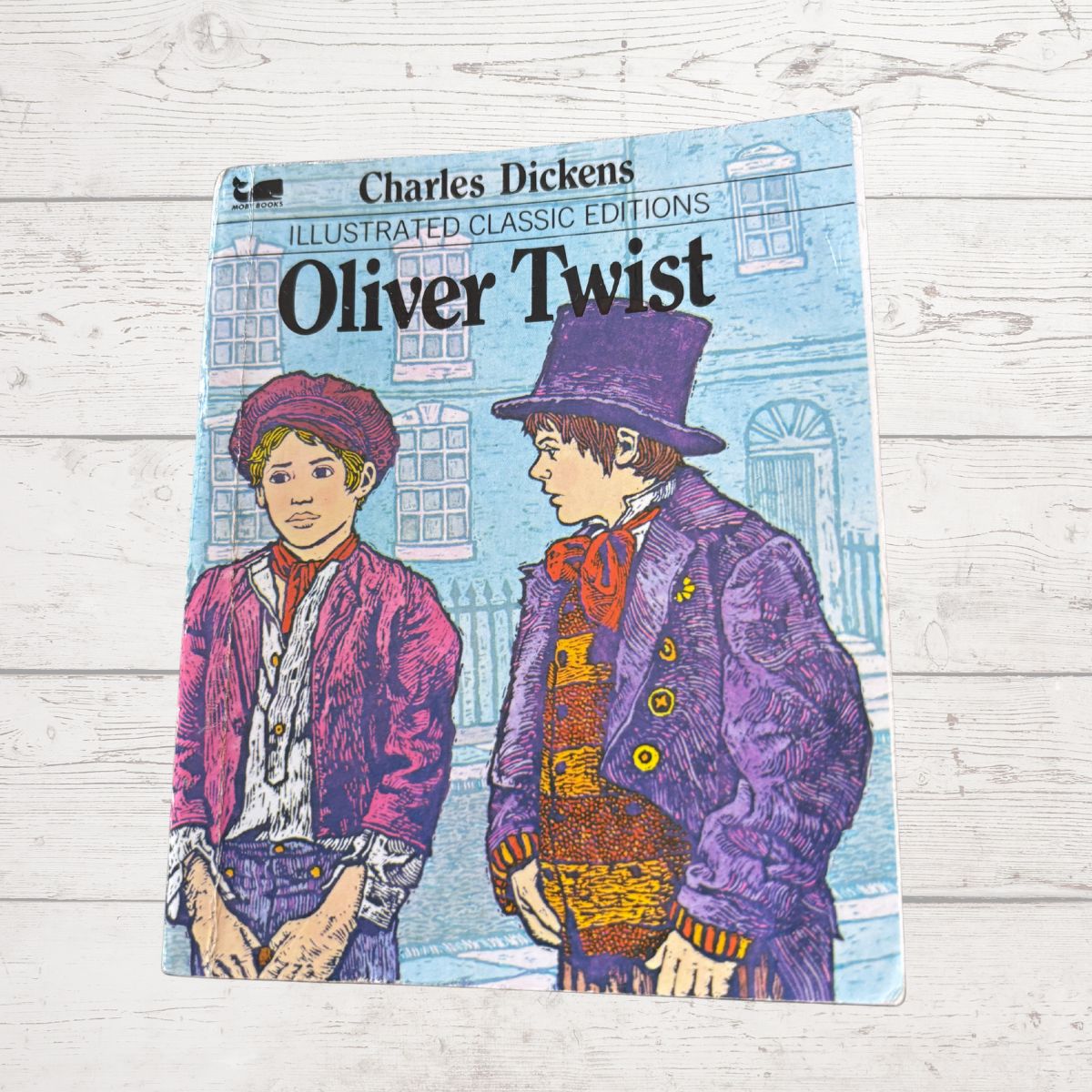Book cover of 'Oliver Twist' by Charles Dickens on a wooden surface