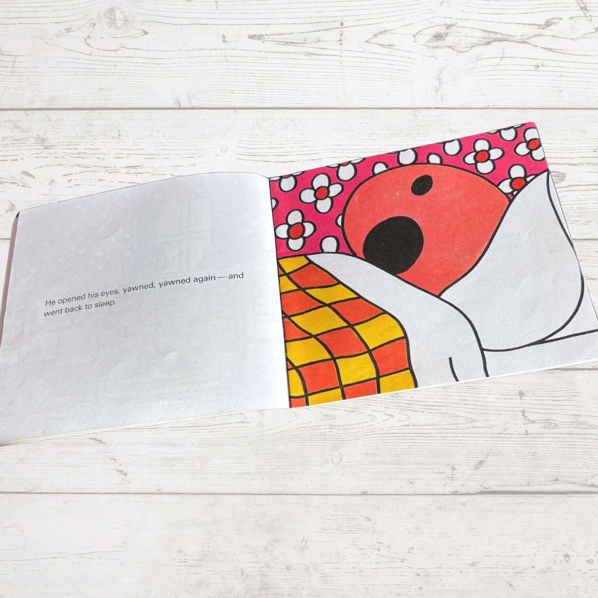 Open book with a colorful illustration of a dog on a wooden surface