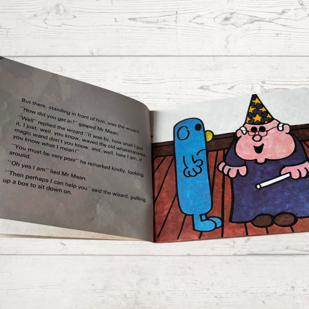 Open book with cartoon characters on a wooden surface