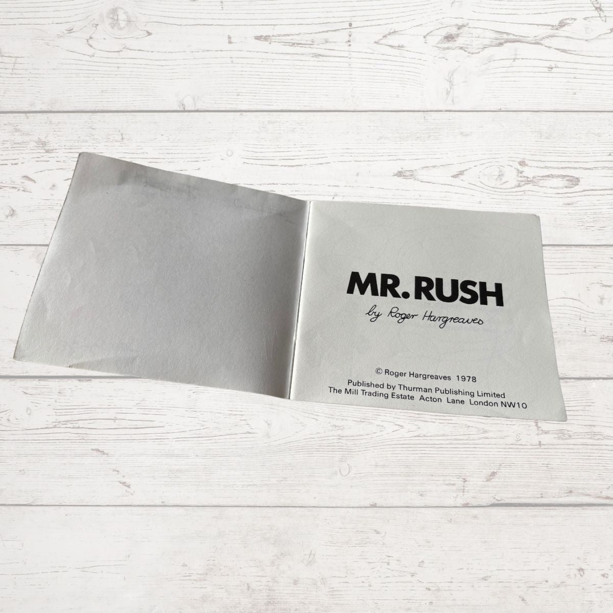 Open book with 'MR. RUSH' title on a white wooden surface
