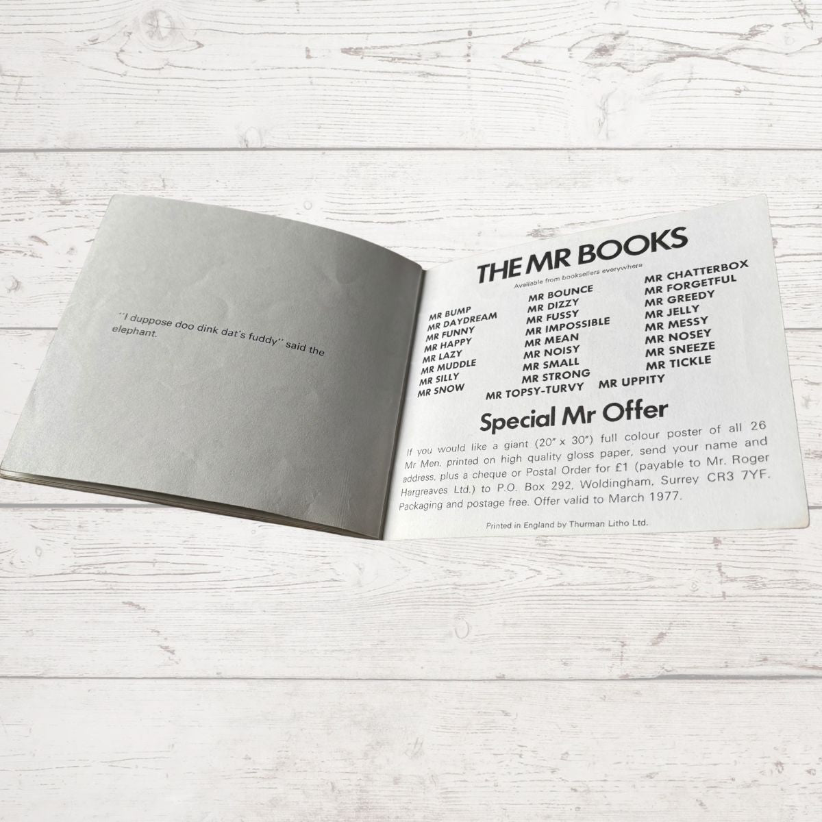 Open book with text on a light wooden surface