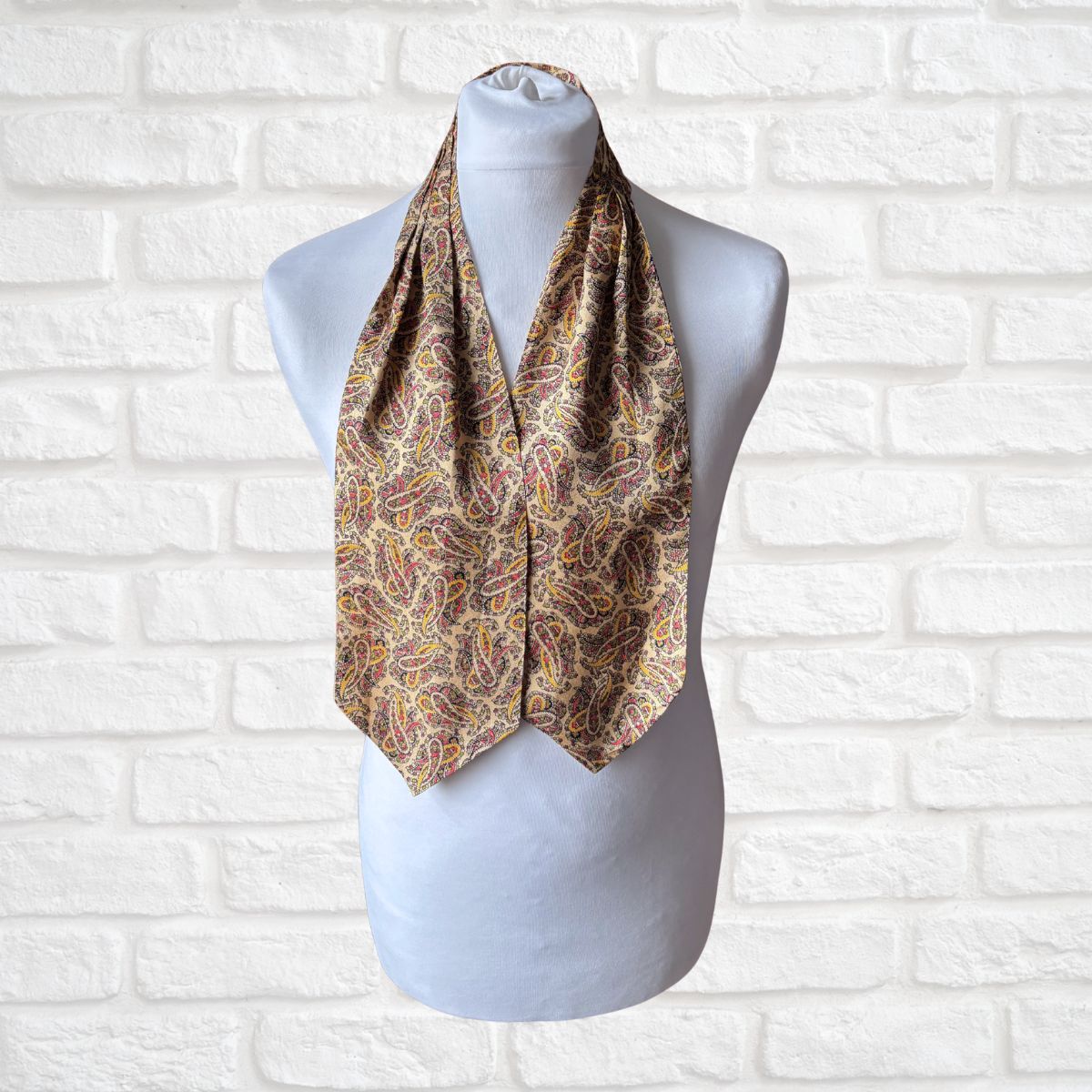 Paisley patterned mens cravat on a mannequin against a white brick wall background