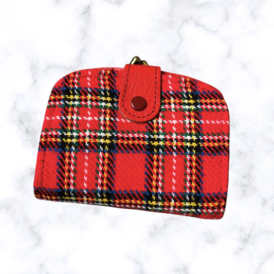 Red plaid wallet with a brown button on a white marble background