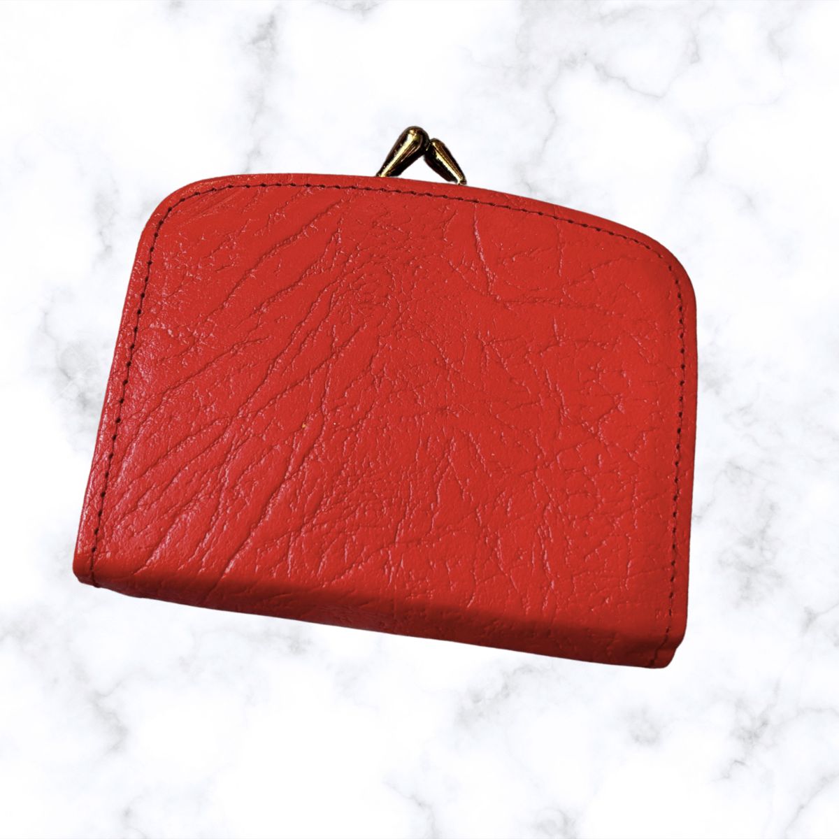 Red leather wallet on a white marble background
