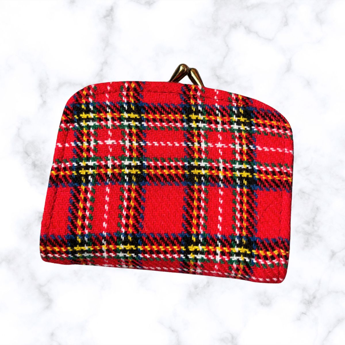 Red plaid pouch on a white marble background