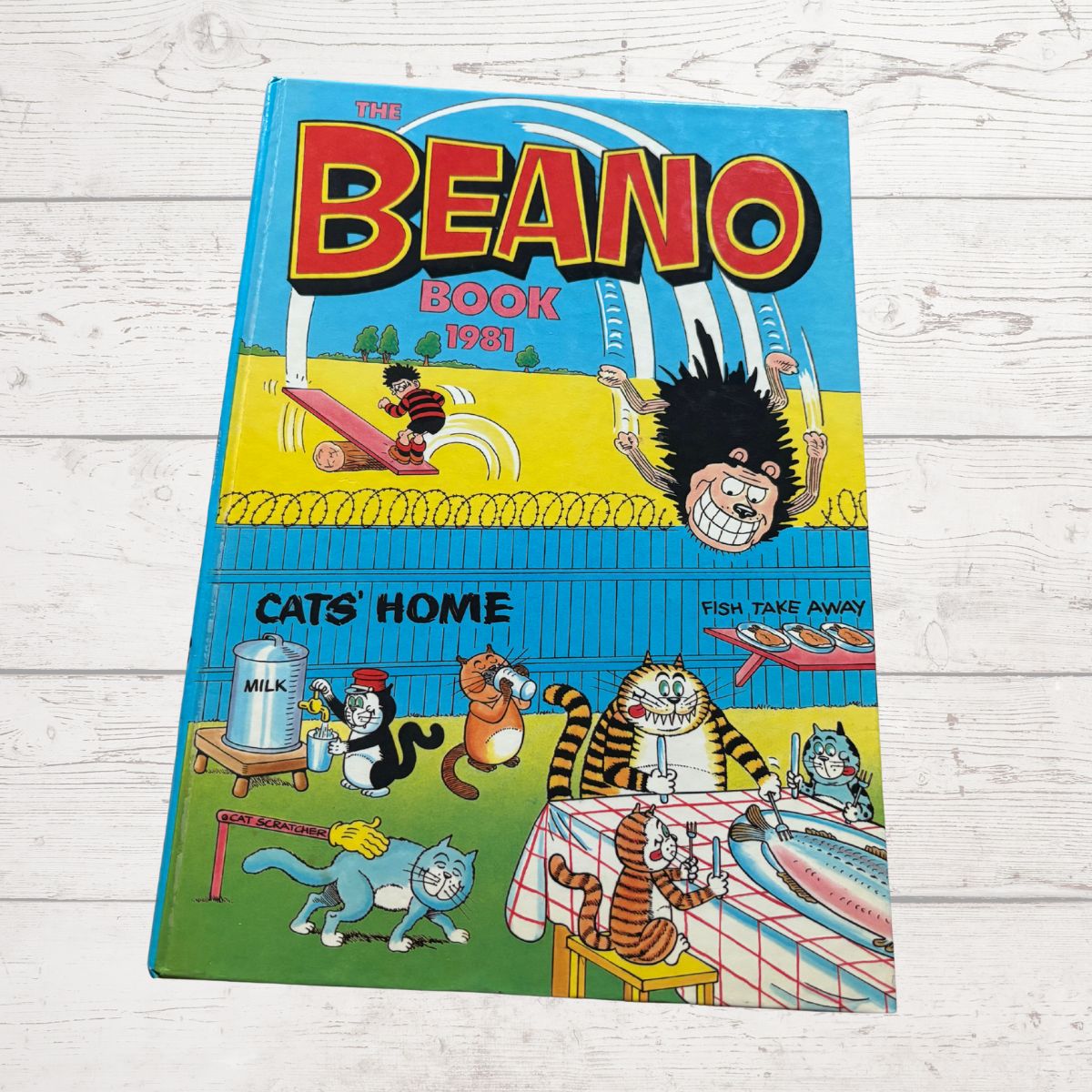 Cover of The Beano Book 1983 on a wooden surface