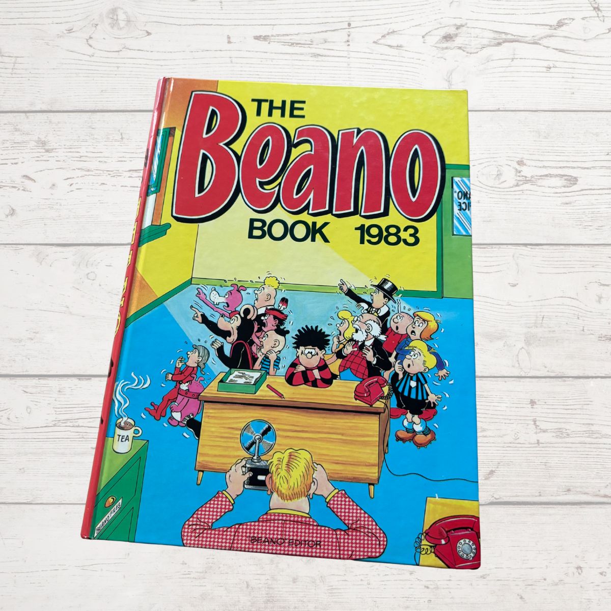Vintage 'The Beano Book 1983' comic on a wooden surface