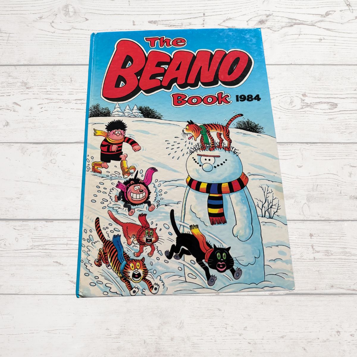 Vintage 'The Beano Book 1984' on a light wooden surface