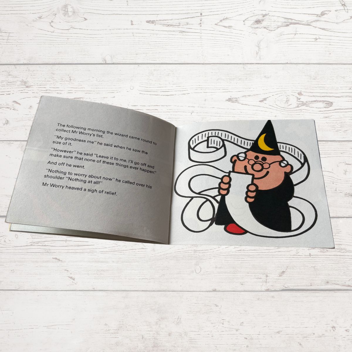 Open book with a cartoon character on a wooden surface