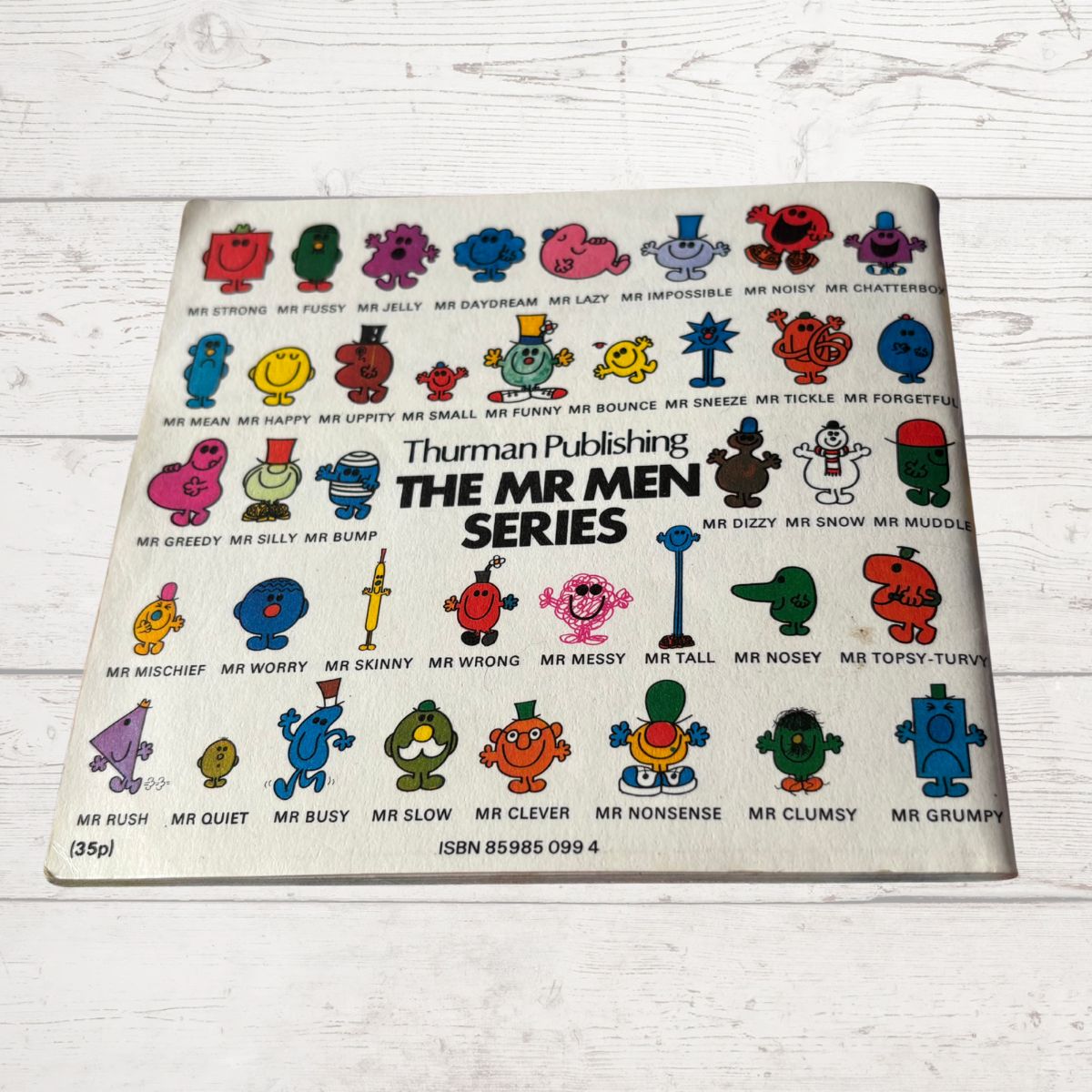 Vintage book cover of 'The Mr Men Series' with character illustrations on a white wooden surface.