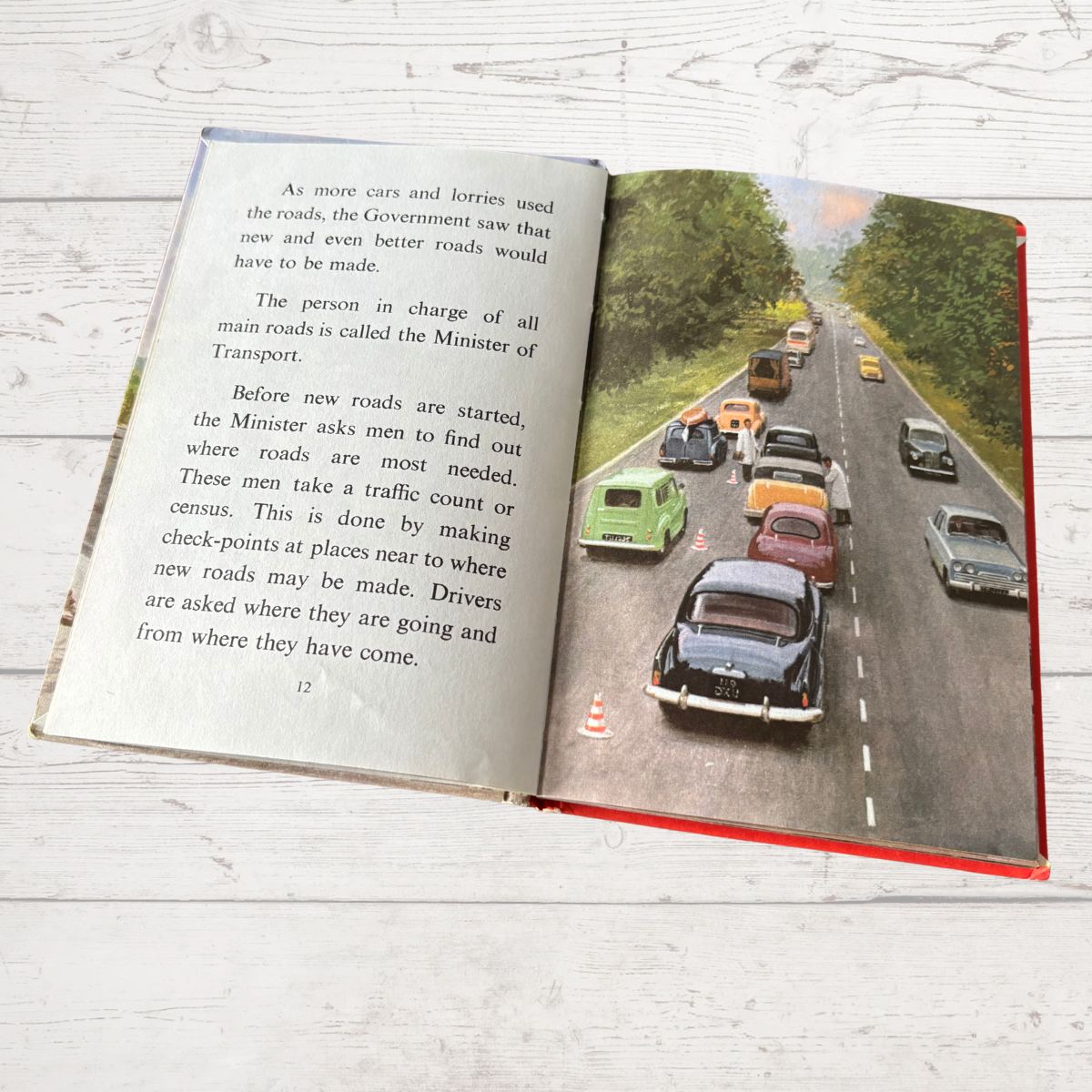 Open book with a road scene and text on a wooden surface