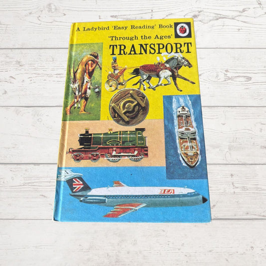 Book titled 'Transport' by Ladybird on a wooden surface