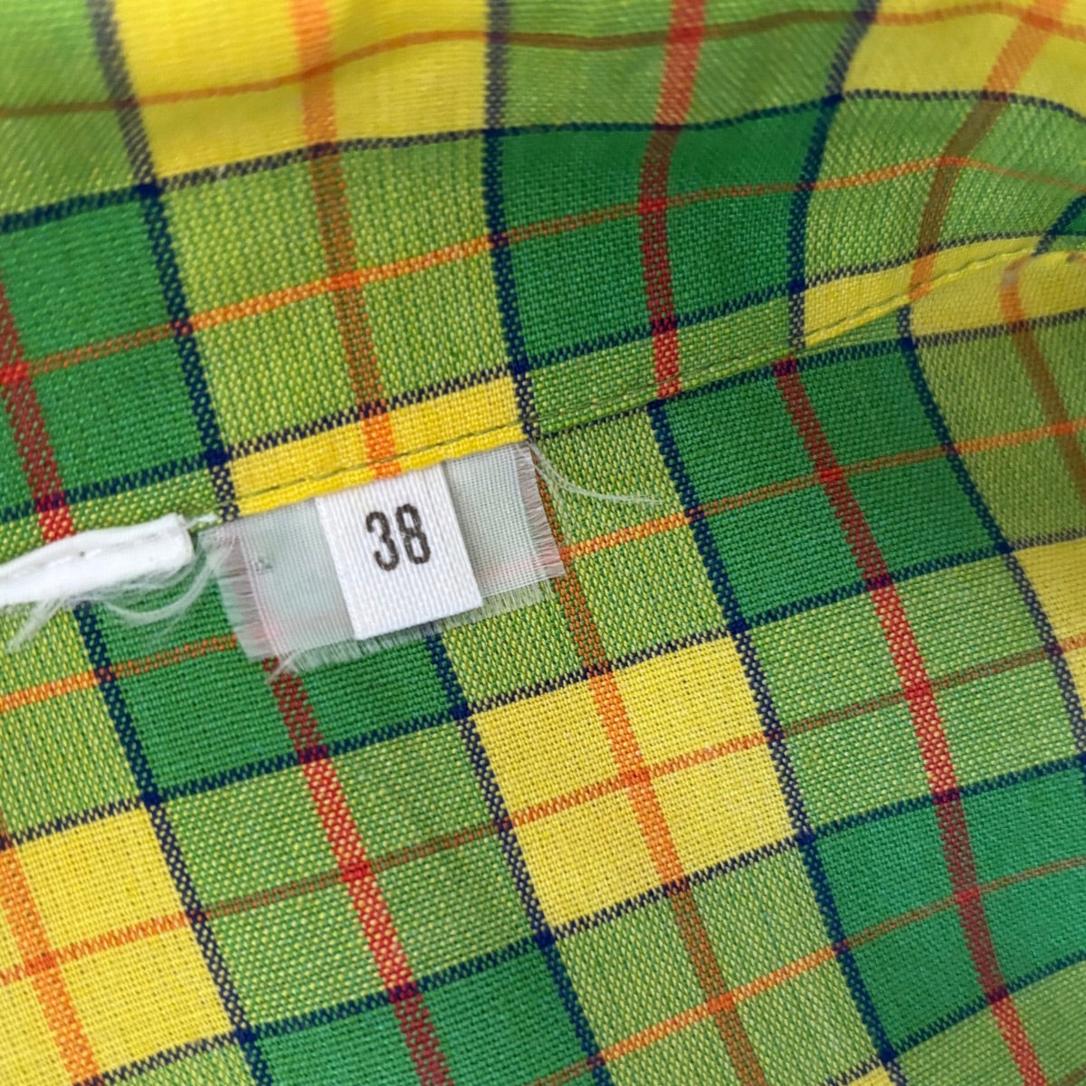 Green and yellow plaid fabric with a size tag displaying the number 38.