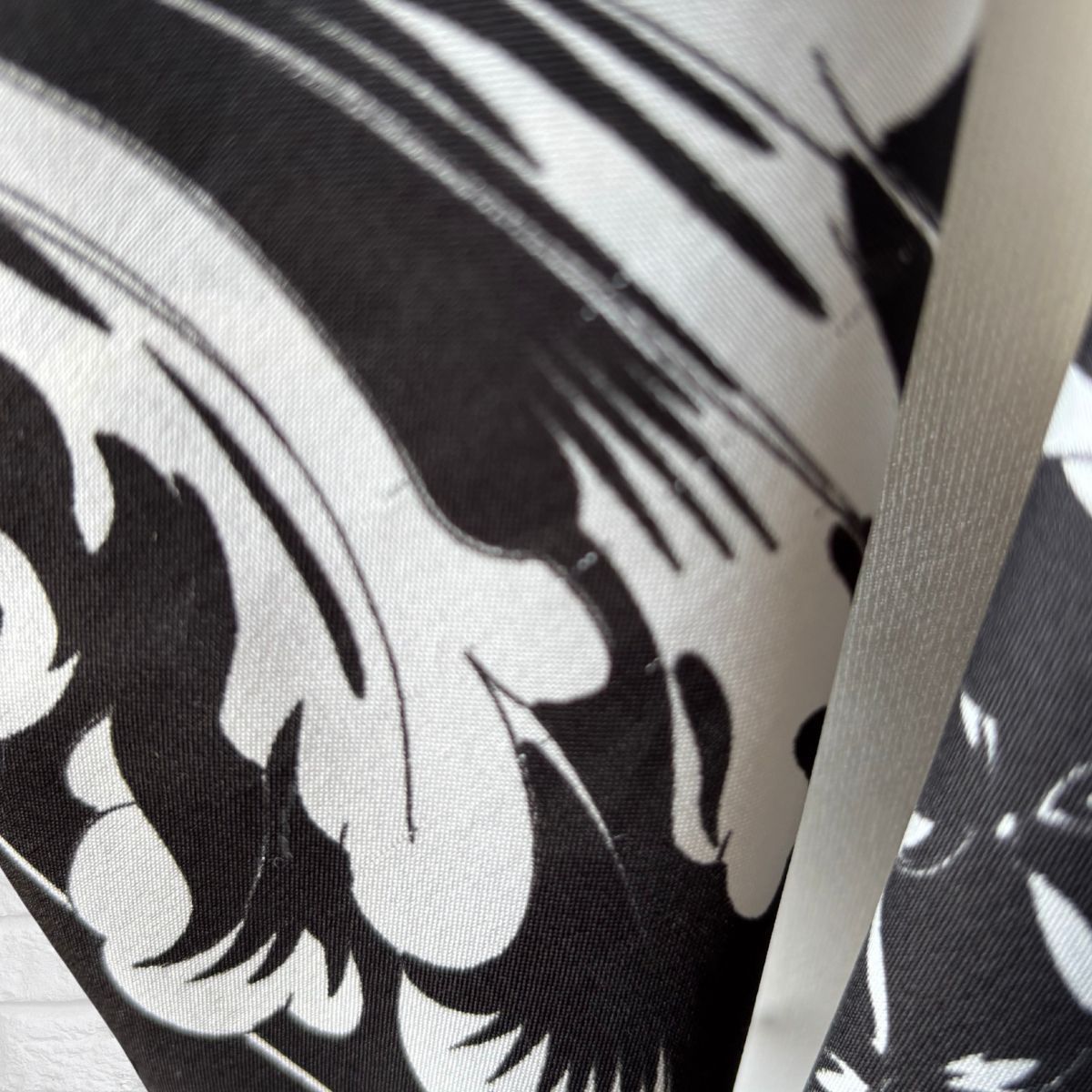Close-up of a black and white patterned fabric with a visible brand logo.