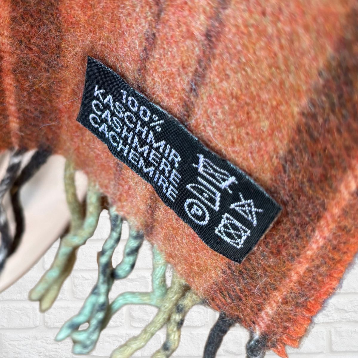 Close-up of a 100% Cashmere label on a textured fabric background