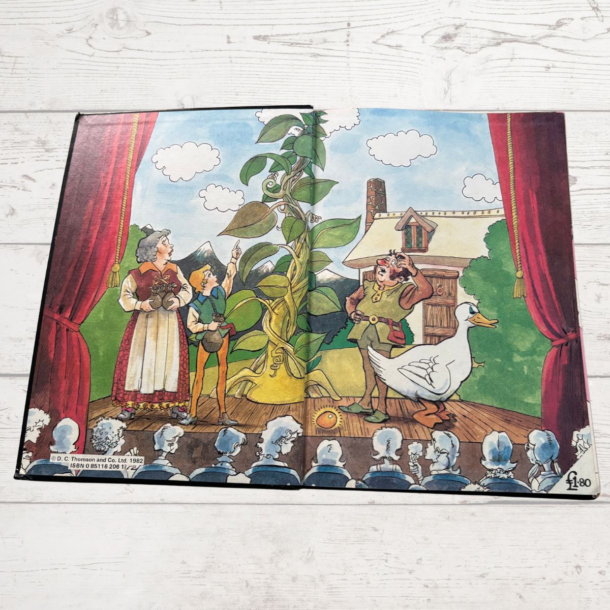 Illustrated book cover with a fairy tale scene featuring a goose and villagers on a stage.