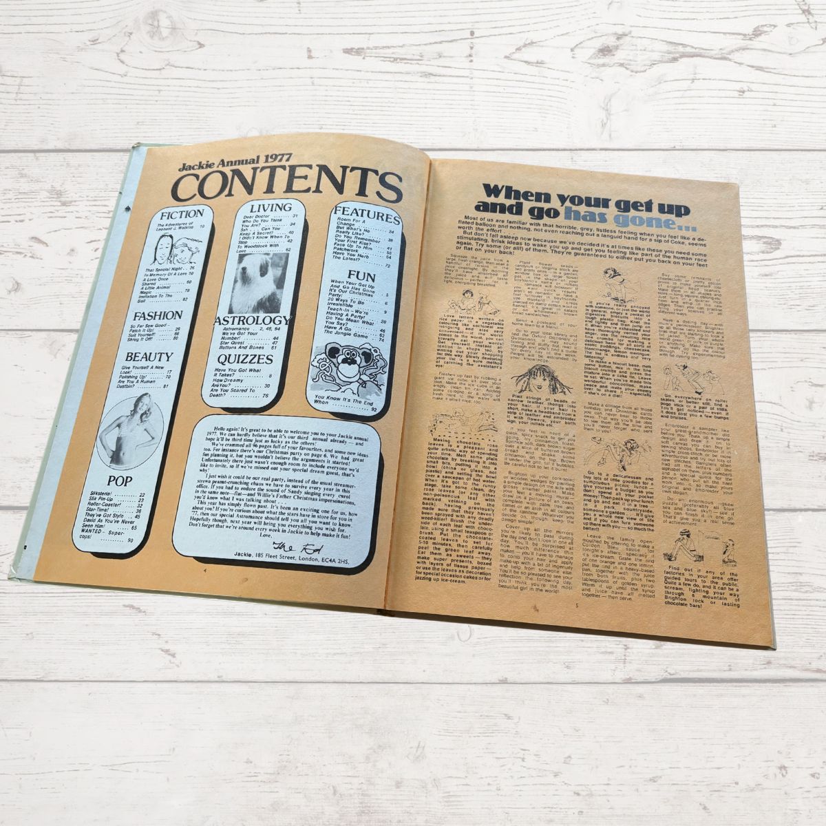 Open book showing a magazine layout with text and illustrations on a wooden surface