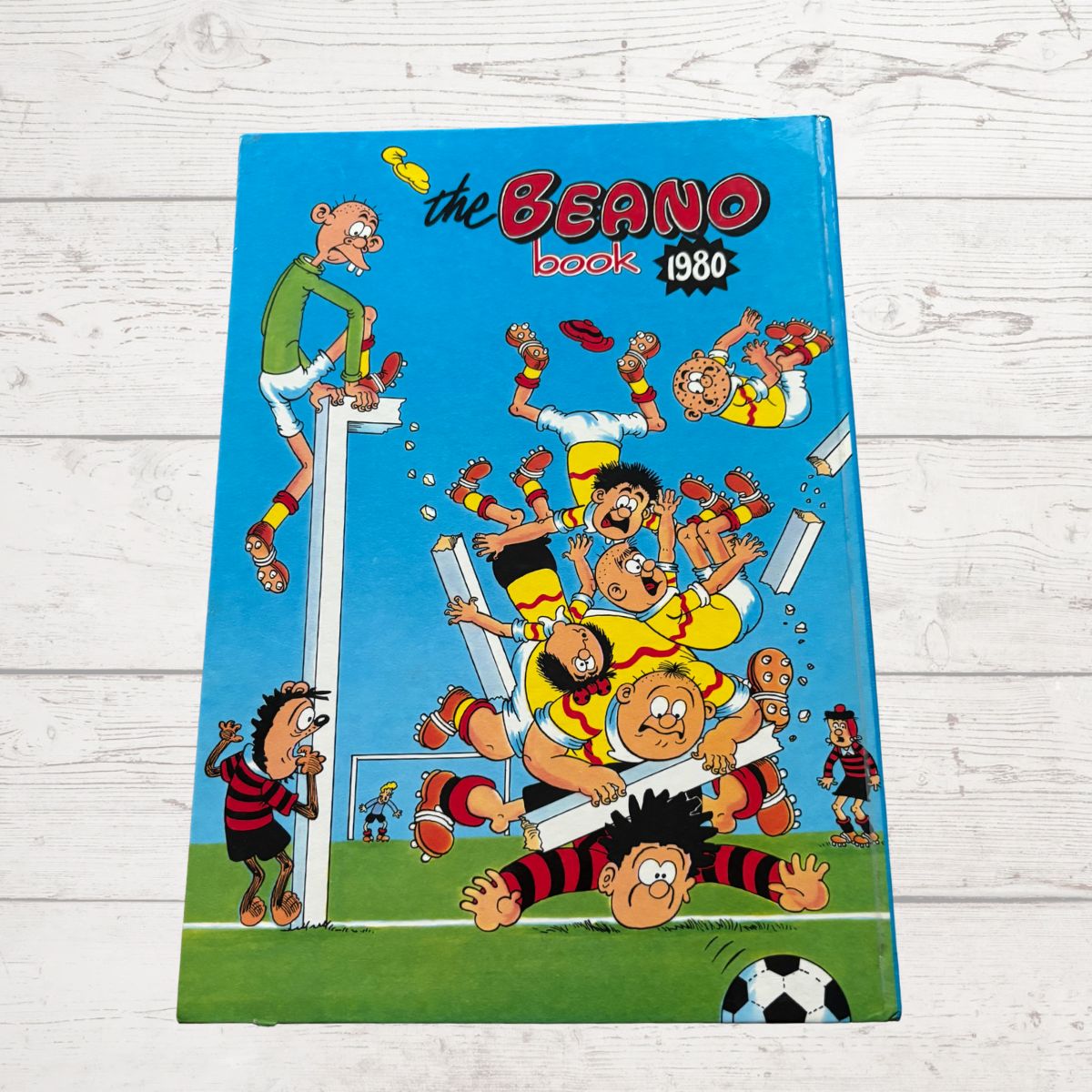 1980 Beano book cover with cartoon characters on a wooden surface