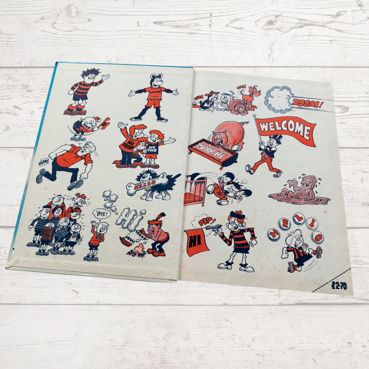 Open book with vintage cartoon character illustrations on a wooden surface