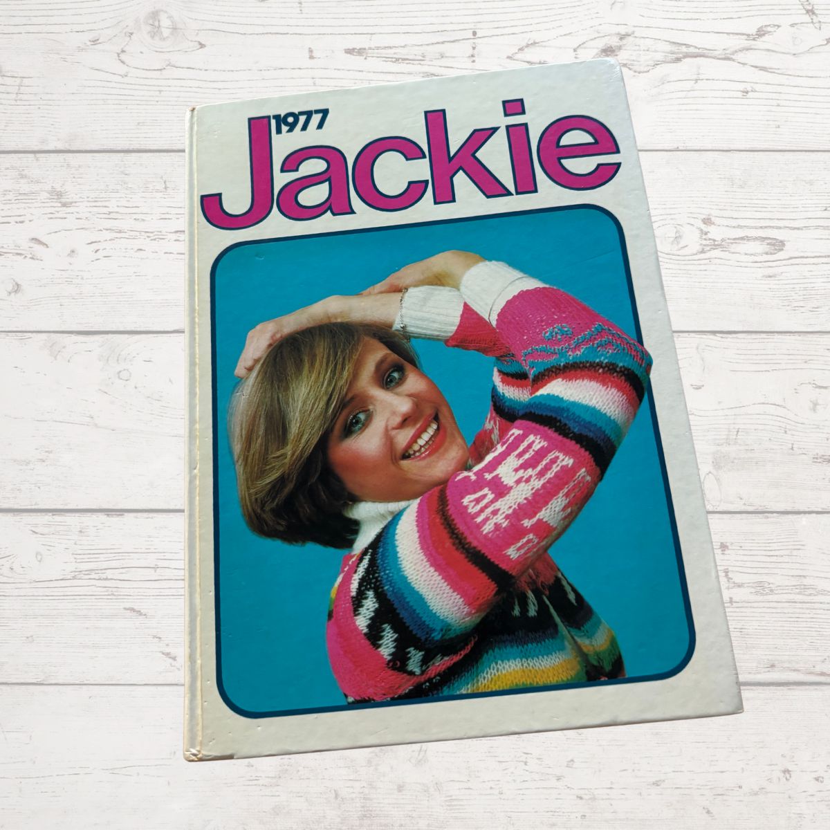 Annual  cover titled '1977 Jackie' featuring a person in a colourful sweater on a blue background.